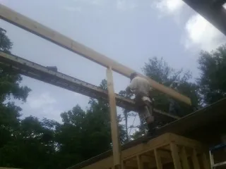 Carpenter setting a ridge beam over a new addition frame — Ice Dam Removal by Roofing Brothers in Cashion