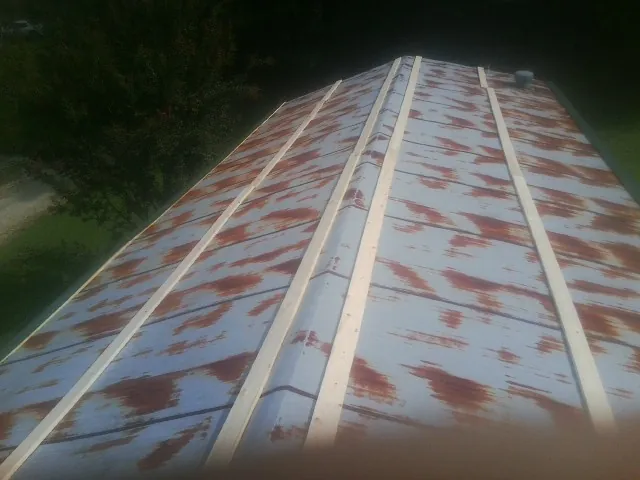Rusted metal roof panels with new wood purlins before replacement — Storm Damage Roof Repair in Cashion by Roofing Brothers